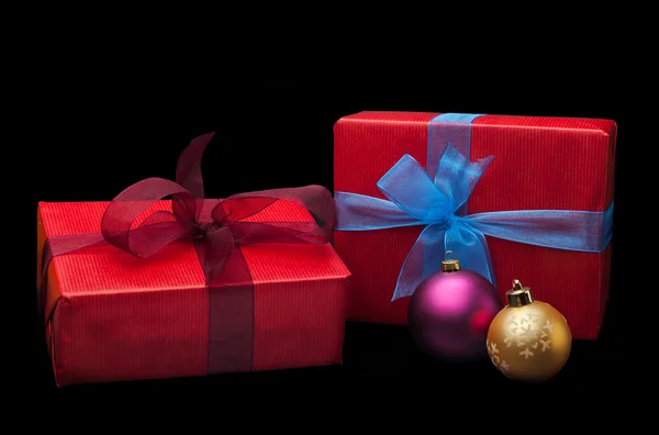 Christmas gifts, with balls. Isolated on black background — Stock Photo, Image