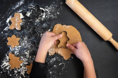 Çocukların elleri, tahta bir masada yeni yıl kurabiyesi yapar. Yeni yıl ve Noel konsepti.