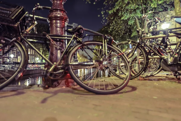 Vélos garés près du canal la nuit à Amsterdam — Photo