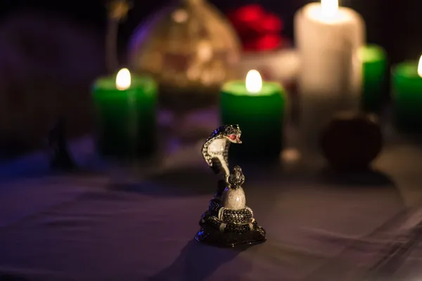 Slang standbeeld met kaarsen en kerstboom aan de achterkant — Stockfoto
