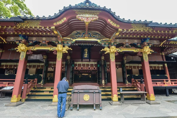 ТОКИО, Япония - CIRCA 2015: мужчина стоит в молитве перед входом в храм в Токио, Япония — стоковое фото