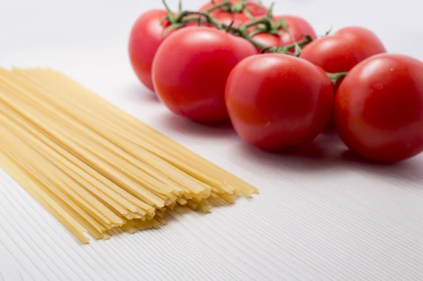 Tomatoes and spaguetti on raw — Stock Photo, Image