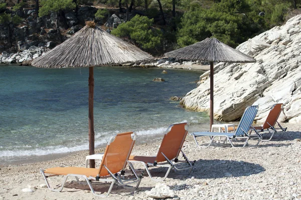 Liegestühle unter Sonnenschirmen am sonnigen Strand — Stockfoto