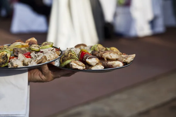 Garçom carregando pratos de comida — Fotografia de Stock