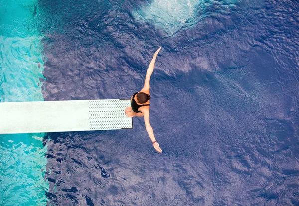 Girl standing on springboard, preparing to dive — Stock Photo, Image