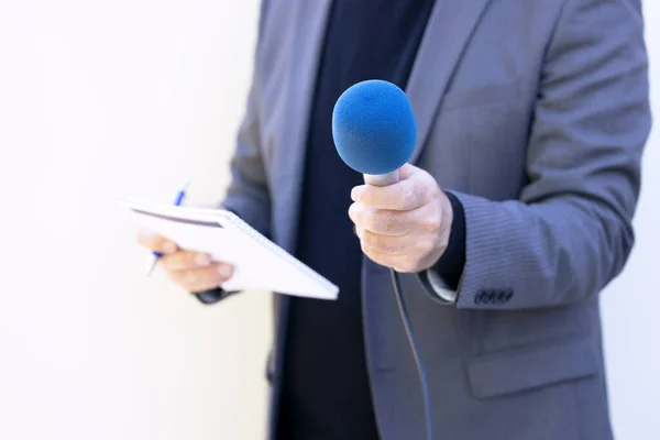 Reporter holding microphone making media interview