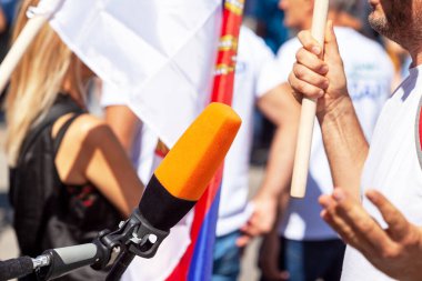 Sokak gösterileri sırasında tanınmayan kişilerle medya röportajı