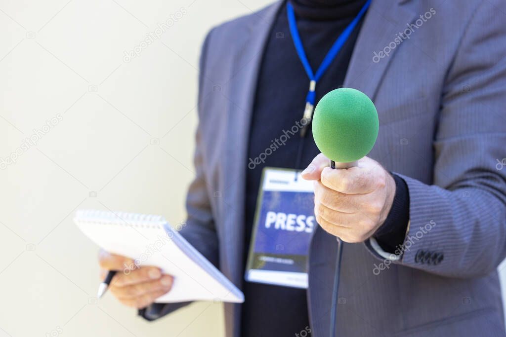 Reporter holding microphone making media interview