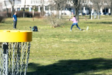 İnsanlar parkta ya da doğada uçan disk golf oynuyorlar.