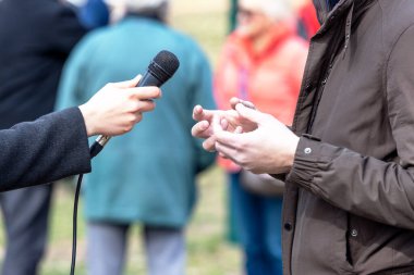 Gazeteci tanınmayan kişilerle basın veya vox pop röportajı yapıyor