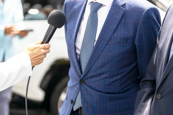 Journalist making media or press interview, female hand holding microphone