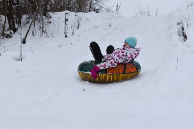 children play in the snow in winter.  fun winter games. Funny baby riding on a sled. Winter vacation for children.