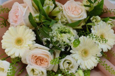 Çiçek aranjmanı masada. Dekoratif çiçek süslemesi. Çiçekçi. Rengarenk çiçeklerden oluşan güzel bir buket. Çiçekçiden çiçek teslimatı. Sevgililer Günü