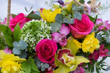 Çiçek aranjmanı masada. Dekoratif çiçek süslemesi. Çiçekçi. Rengarenk çiçeklerden oluşan güzel bir buket. Çiçekçiden çiçek teslimatı. Sevgililer Günü