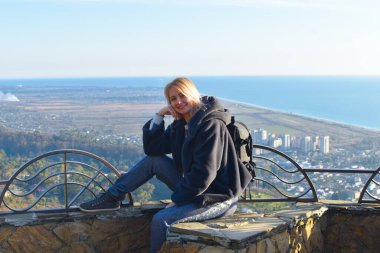 Sonbaharda, Abhazya 'daki dağlarda denizde güzel sarışın bir kadın. Soğuk havada suyun üzerinde sakin ol. Kışın Karadeniz 'de tatiller