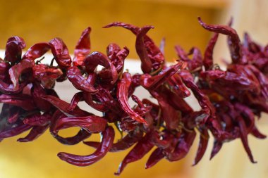 Duvarda kırmızı kırmızı kırmızı kırmızı biberler asılı. Doğal baharat..