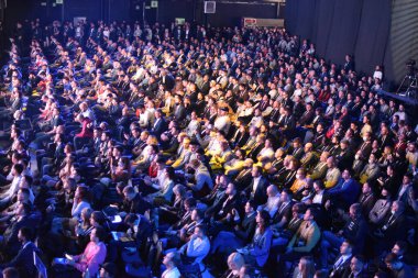 Konferanstaki konferans salonunda bir sürü insan oturuyor. Koltuklarda pek çok kişinin hoparlörü dinlediği engelleme oturumu. Kripto para birimi ve engelleme zinciri konulu en büyük uluslararası forum. 