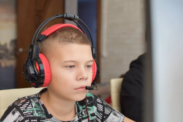Ένα Αγόρι Ακουστικά Κάθεται Έναν Υπολογιστή Και Παίζει Ένα Παιχνίδι — Φωτογραφία Αρχείου