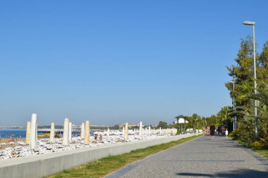 Yazın deniz kıyısında gezinti. Pramenad plajı boyunca beton yol