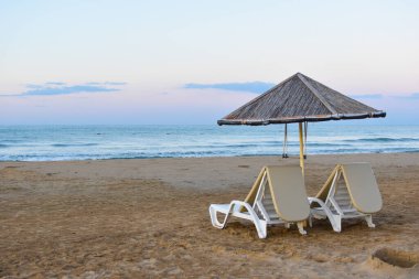 Deniz sahilinde güneşlenmek için güneşleniyorlar. Yazın mavi denizin kenarında güneşlenen insanlar olmadan.