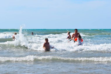 people tourists swim in the sea in summer. happy holidays on the seaside.