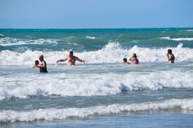 people tourists swim in the sea in summer. happy holidays on the seaside.