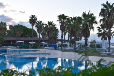 expensive luxury hotel with a pool under the palm trees. sunset in a luxury hotel in the tropics