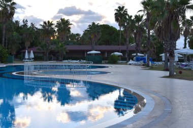 expensive luxury hotel with a pool under the palm trees. sunset in a luxury hotel in the tropics