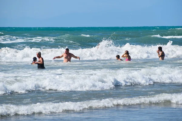 people tourists swim in the sea in summer. happy holidays on the seaside.