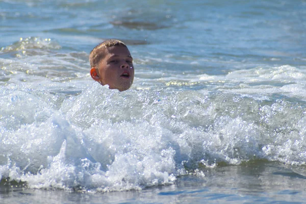 一个男孩子在蓝色的海里洗澡 海滨的夏天旅游孩子们的季节 — 图库照片