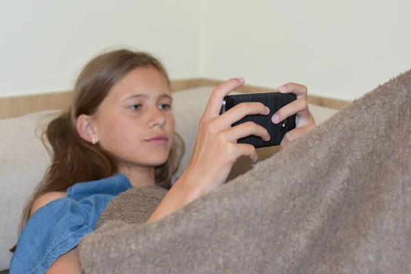 Girl Looks Phone Child Girl Plays Online Smartphone — Zdjęcie stockowe