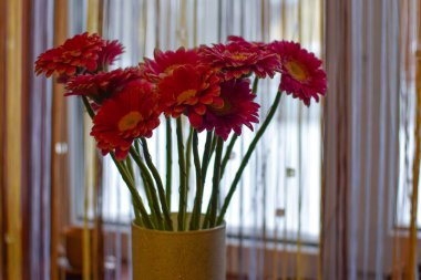 pink gerberas in a vase on the window in the house. spring bouquet of flowers on the windowsill