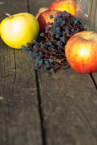 Apples on wooden table over autumn bokeh background — Stock Photo, Image