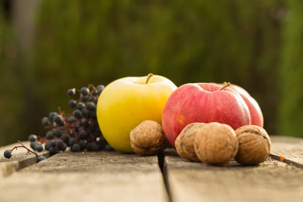 Mele su tavolo di legno su sfondo bokeh autunno — Foto Stock