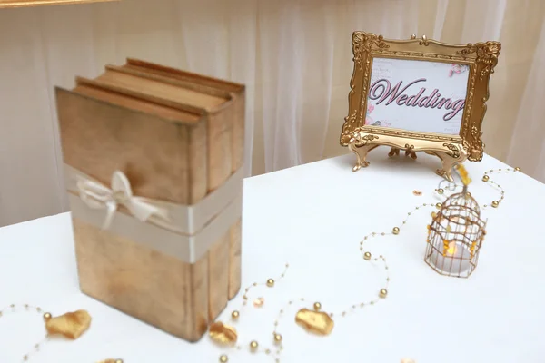 Золота весільна рамка і три золоті книги — стокове фото
