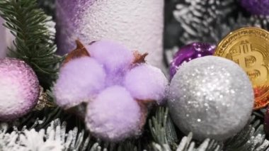 Christmas decorations and souvenir crypto currency Bitcoin rotate in a circle. Pink candle, balls, decorative Christmas tree with snow. New Year Video Background.