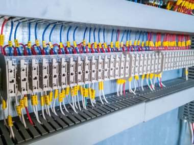 Endüstriyel santraldeki otomasyon sisteminin elektrik dolabına yüklenmiş sigorta sıraları..