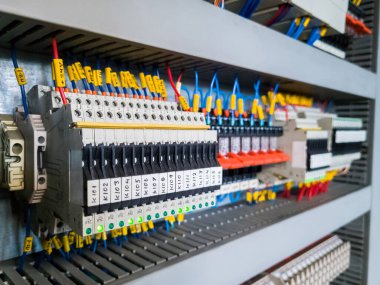 Endüstriyel santraldeki otomasyon sisteminin elektrik dolabına yüklenmiş sigorta ve röleler..