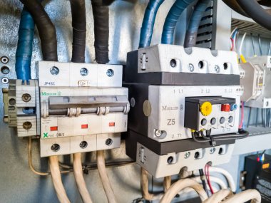 Eski kirli devre kesici ve manyetik güç başlatıcı Moeller endüstriyel santraldeki otomasyon kontrol dolabına yerleştirildi. Elektrik motoru fabrikada çalışıyor. KRYVYI RIH, UKRAINE - Eylül 2022