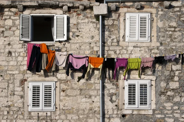 Clothes on the line between four windows — Stock Photo, Image