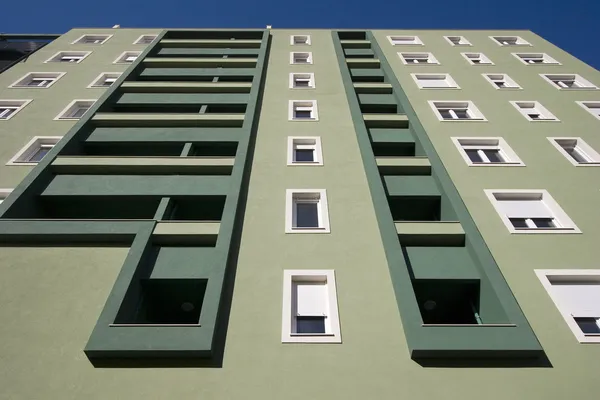 Fachada verde claro e escuro com varandas e janelas brancas — Fotografia de Stock