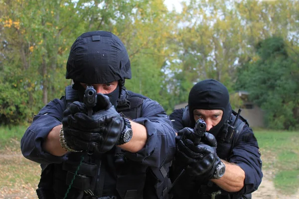 Maskeli polis vuruyor — Stok fotoğraf