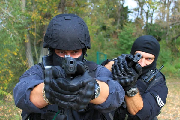 Maskerte politimenn skyter. – stockfoto