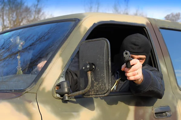 Assassin shooting from a moving car — Stock Photo, Image