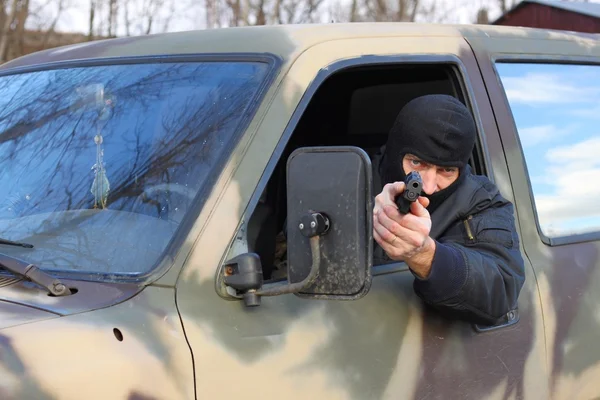 Assassin shooting from a moving car — Stock Photo, Image