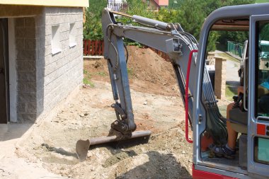 evin bahçesinde küçük bir ekskavatör sağlar