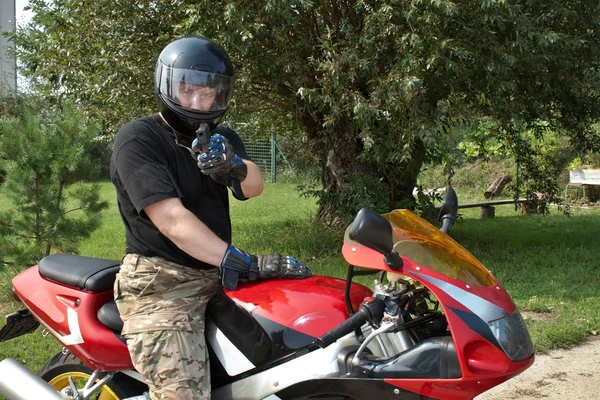 Assassin on a motorcycle fired from a gun — Stock Photo, Image