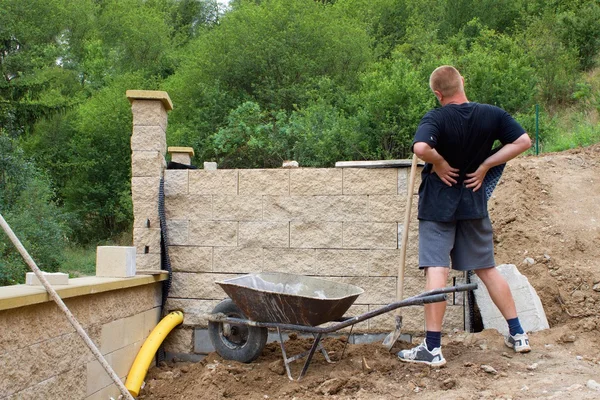 Mal di schiena, muratore costruisce un muro — Foto Stock