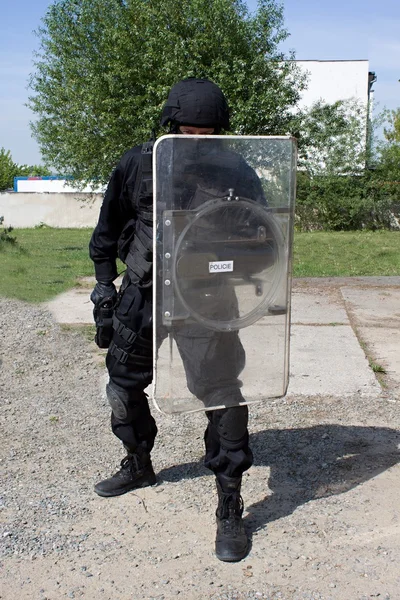 Офицер полиции в защитном шлеме и козырьке, подготовка к демонстрации — стоковое фото
