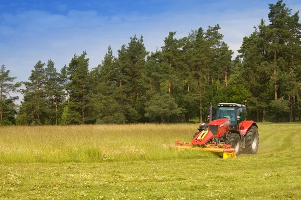 Traktor merah memotong padang rumput, Republik Ceko — Stok Foto